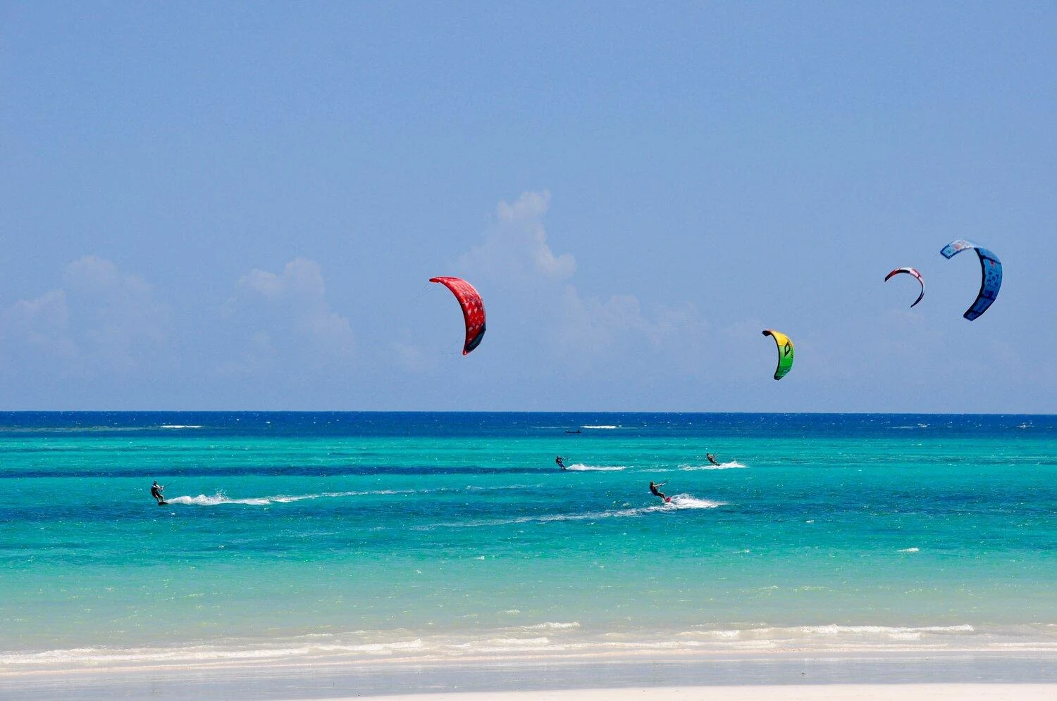 Kitesurfer riding across the turquoise lagoon at <a href=